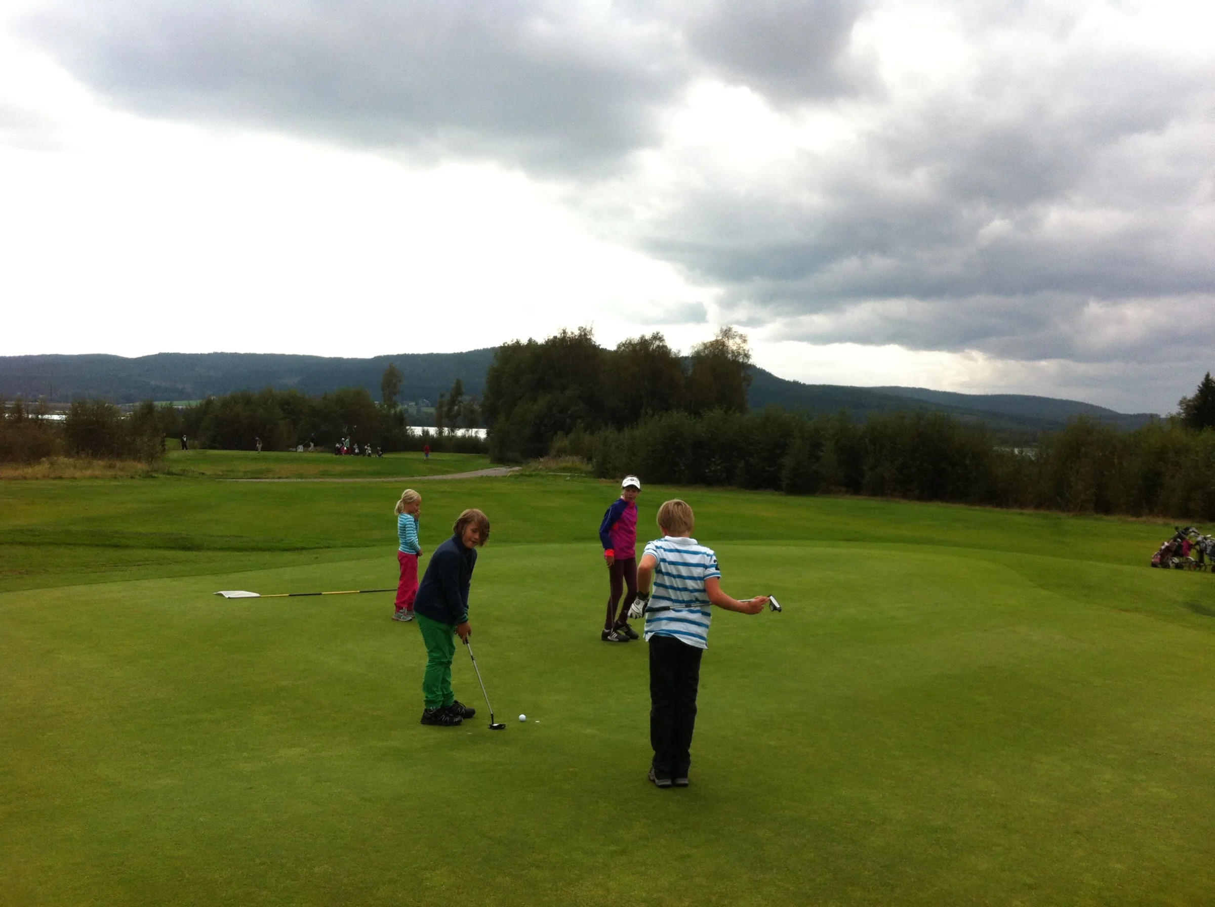 William Wennman gör sig klar att putta på 7:an. Lagkamraterna Zaga Lövdahl, Ida Pekkala och Filip Nordström kollar på.
