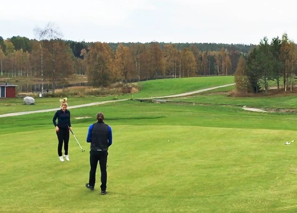 Maria i luften efter en koppsnurr för birdie på hål 18